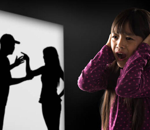 A distressed child watches a shadow of abuse happening.