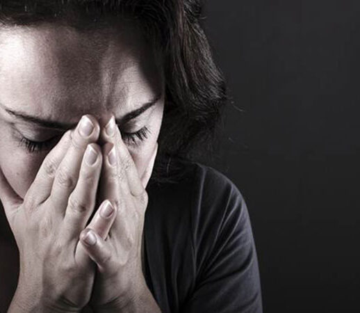 Person covering face with hands, showing distress or sadness.