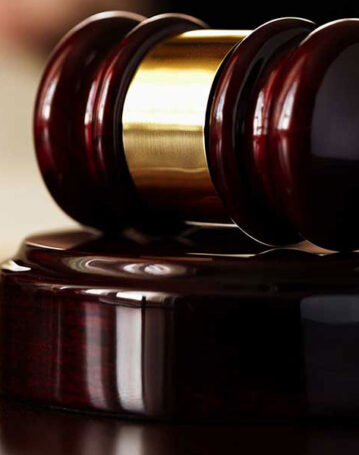 A close-up of a wooden judge's gavel on a block.