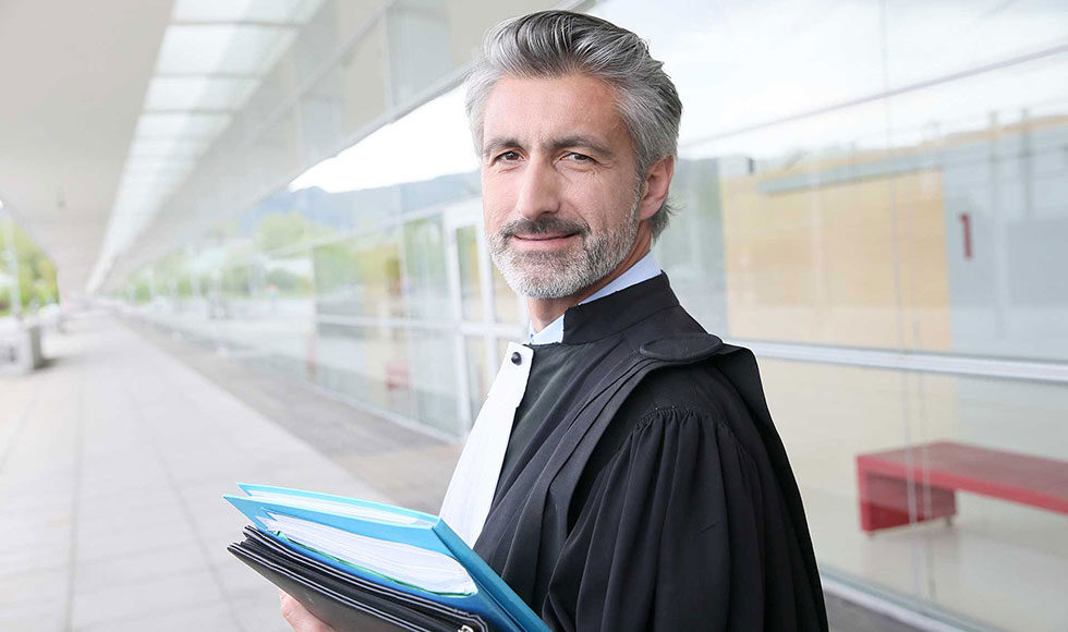 Confident male lawyer holding legal files outdoors.