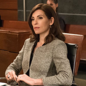 A woman in a gray blazer sitting attentively in a courtroom.